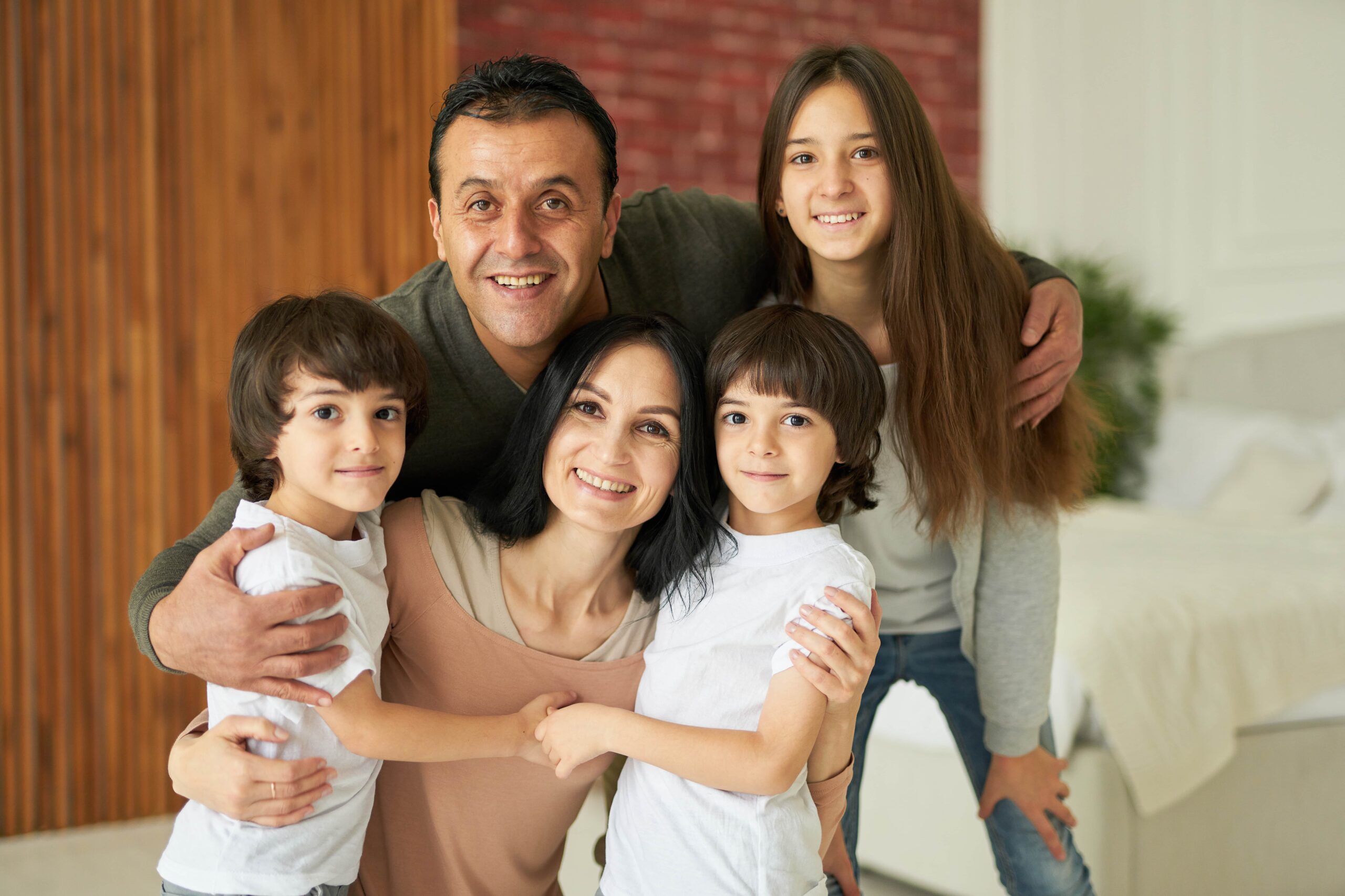 Multicultural family with a mom dad two little boys and a teenage daughter